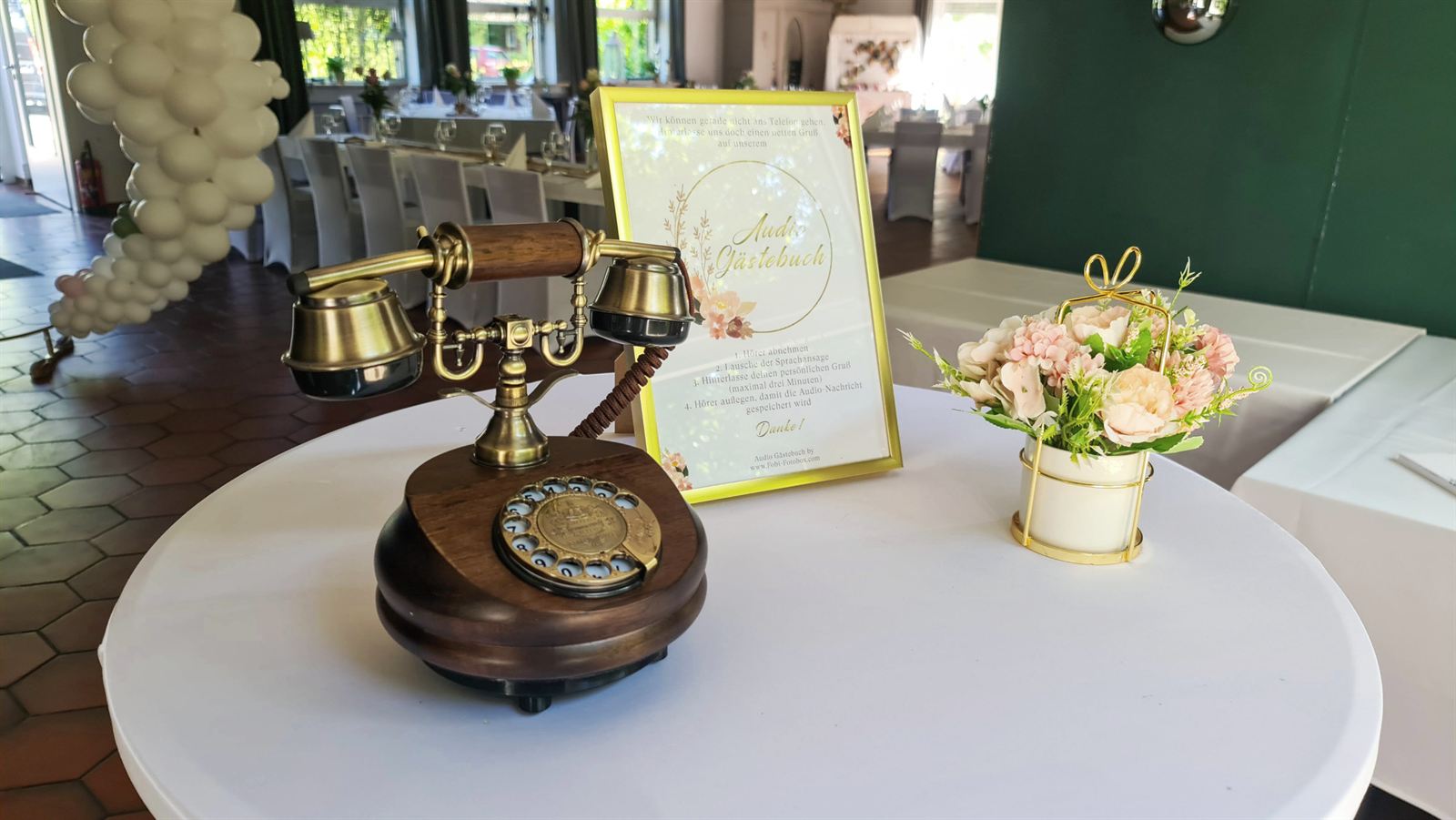 Schnackphone mit Anleitungsschild und Blumen auf einer Hochzeitsfeier